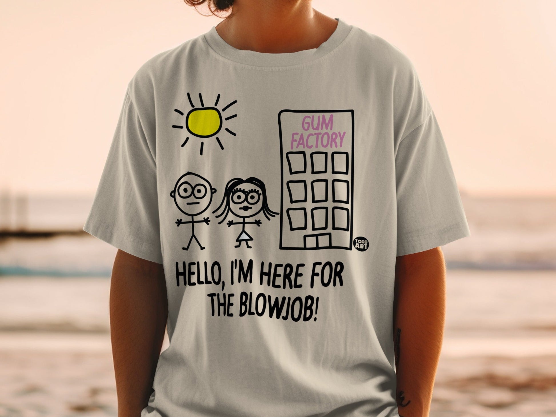 Light grey t-shirt with a drawing of stick figures, a sun, and a factory with "GUM FACTORY" and "HELLO, I'M HERE FOR THE BLOWJOB!" text.