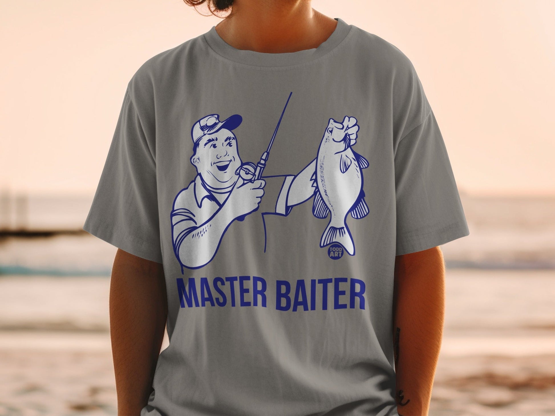 Blue line art of fisherman holding a fish with "MASTER BAITER" text on grey t-shirt.