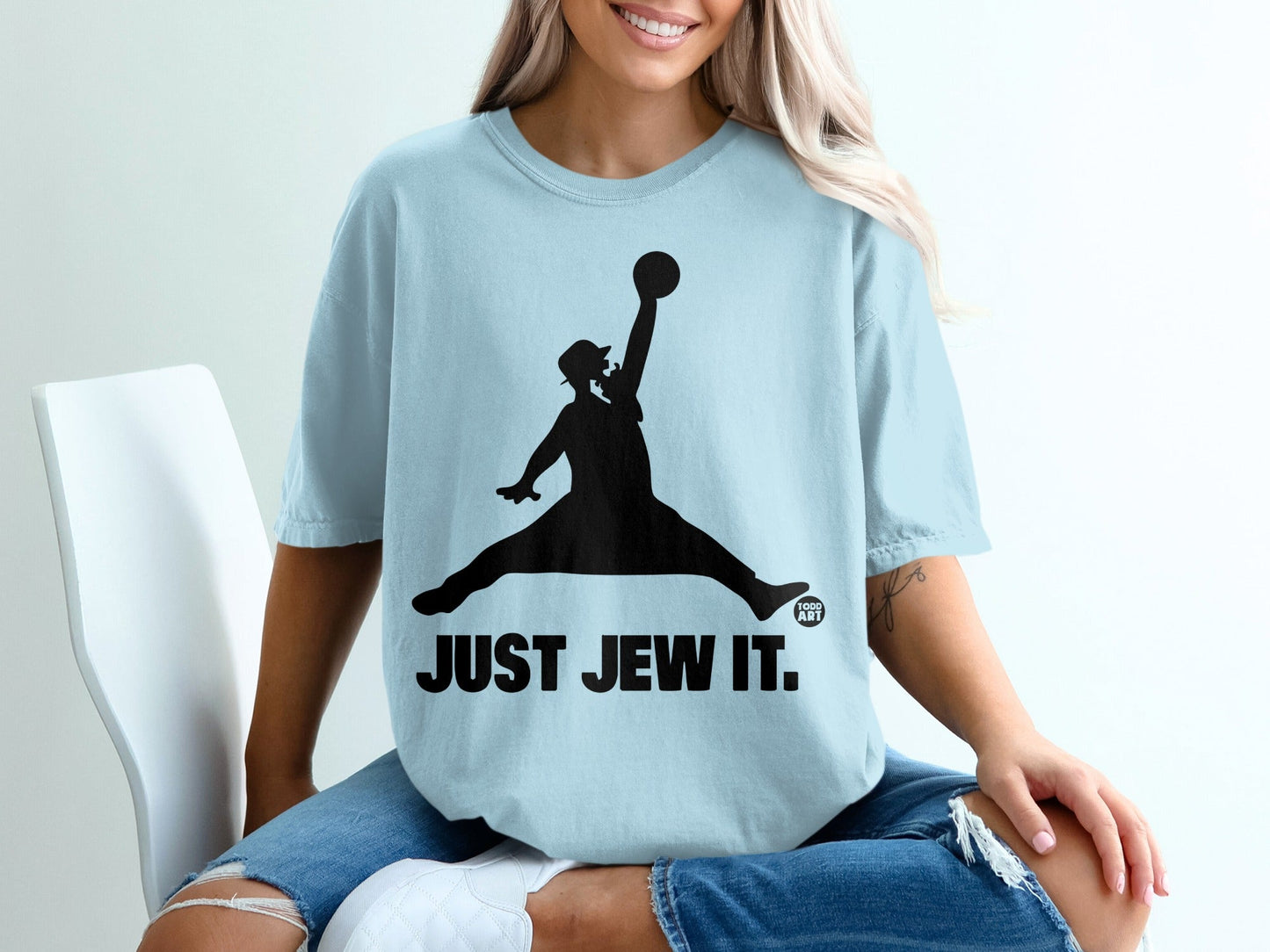 Light blue t-shirt with a black silhouette of a man in a jumping pose with a basketball.