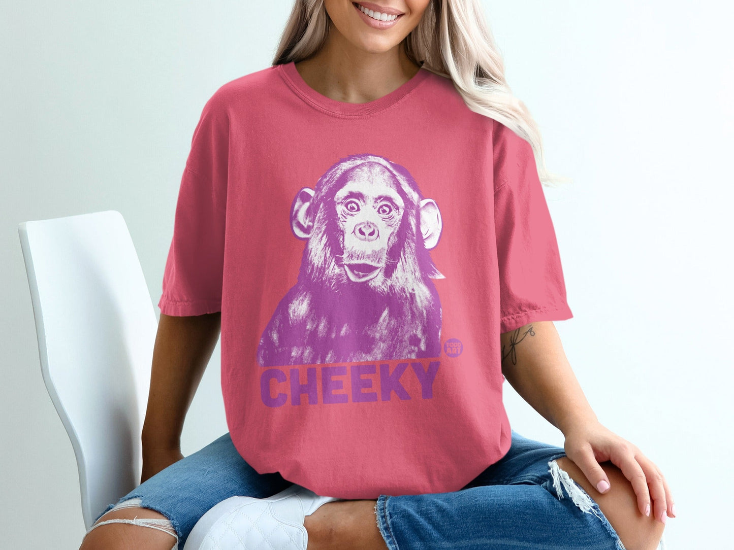 Pink t-shirt with a purple cheeky chimpanzee graphic.