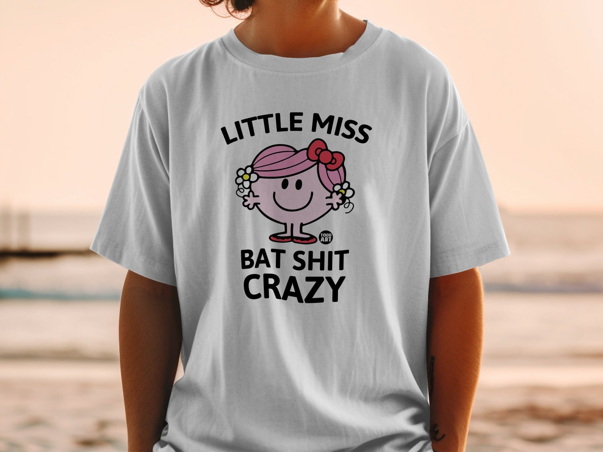 White t-shirt with graphic of Little Miss character and "Bat Shit Crazy" text.