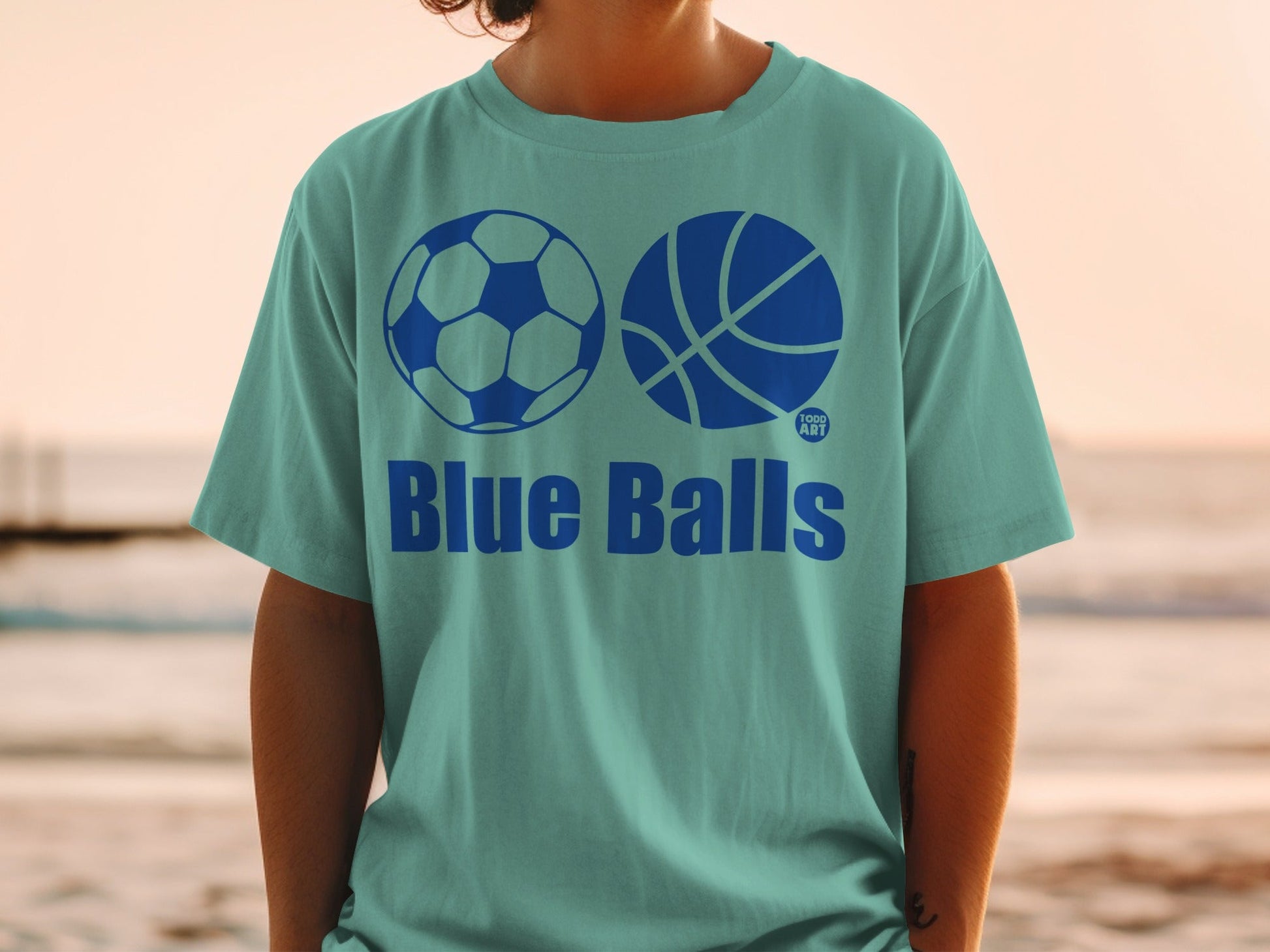 Teal t-shirt with soccer ball, basketball, and "Blue Balls" text.