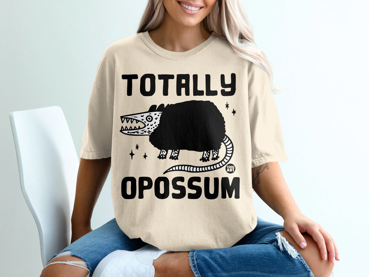 T-shirt with "TOTALLY OPOSSUM" text and graphic of a spiky opossum.