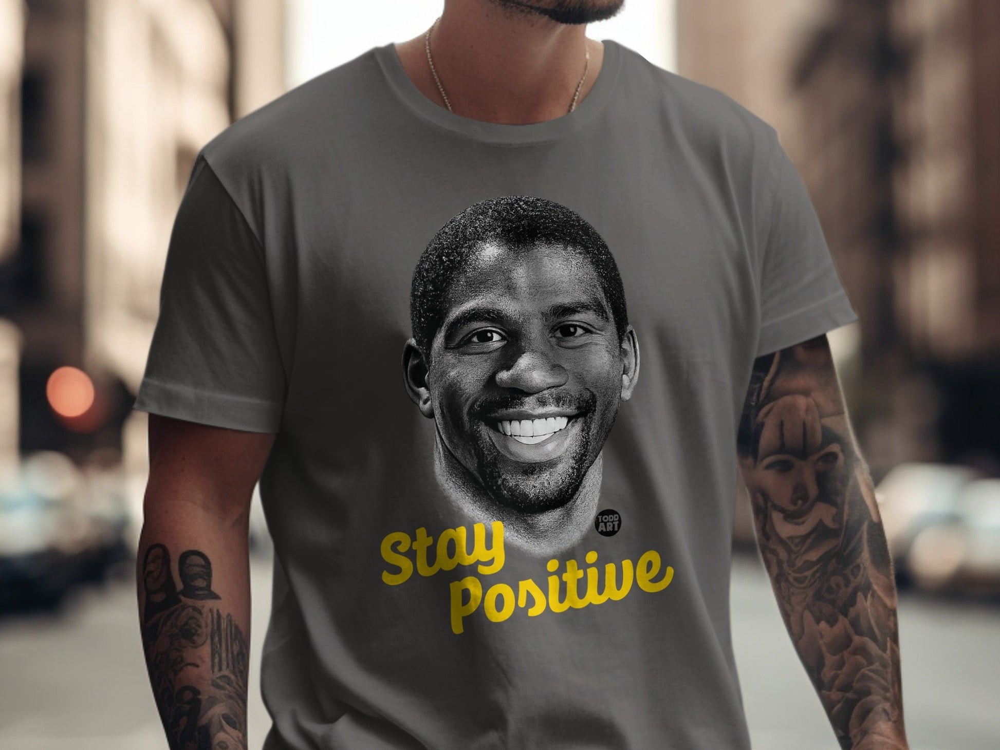 Gray t-shirt with Magic Johnson's portrait and "Stay Positive" text.