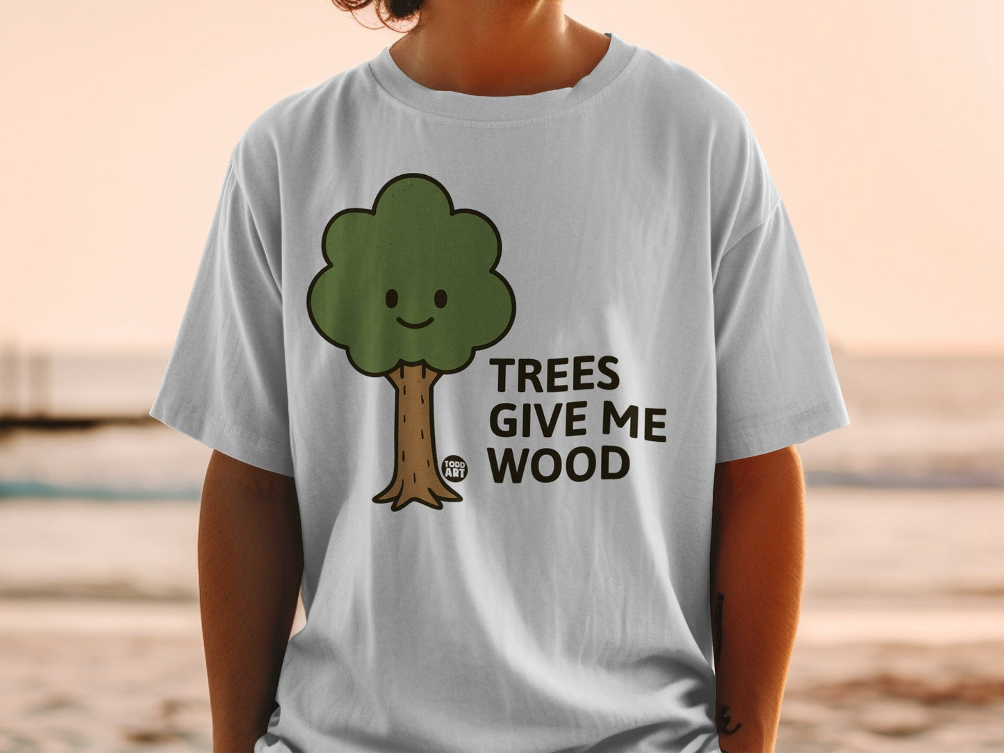 White t-shirt with cartoon tree graphic and text "TREES GIVE ME WOOD".