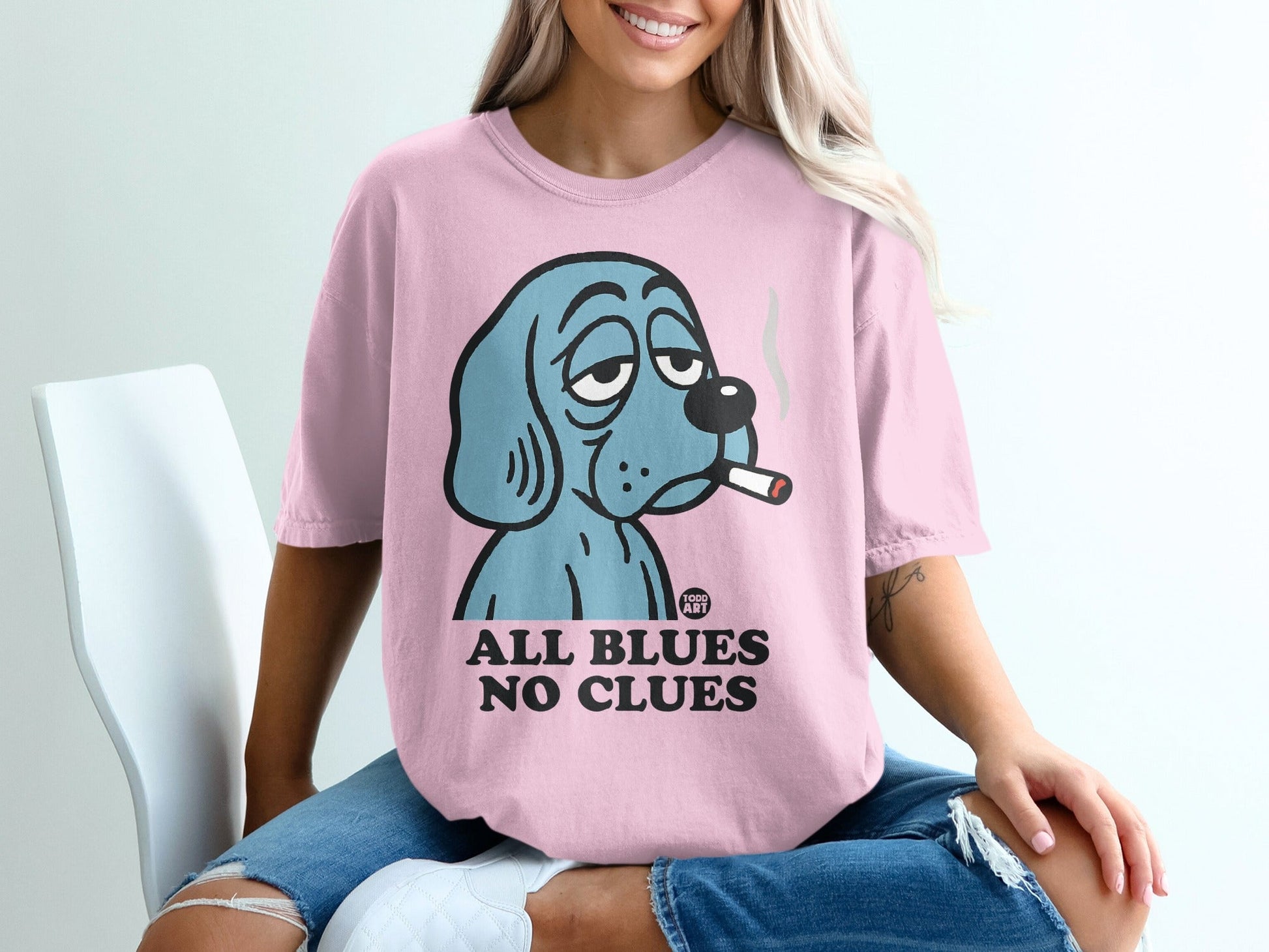 Pink t-shirt with cartoon dog smoking and text "ALL BLUES NO CLUES".