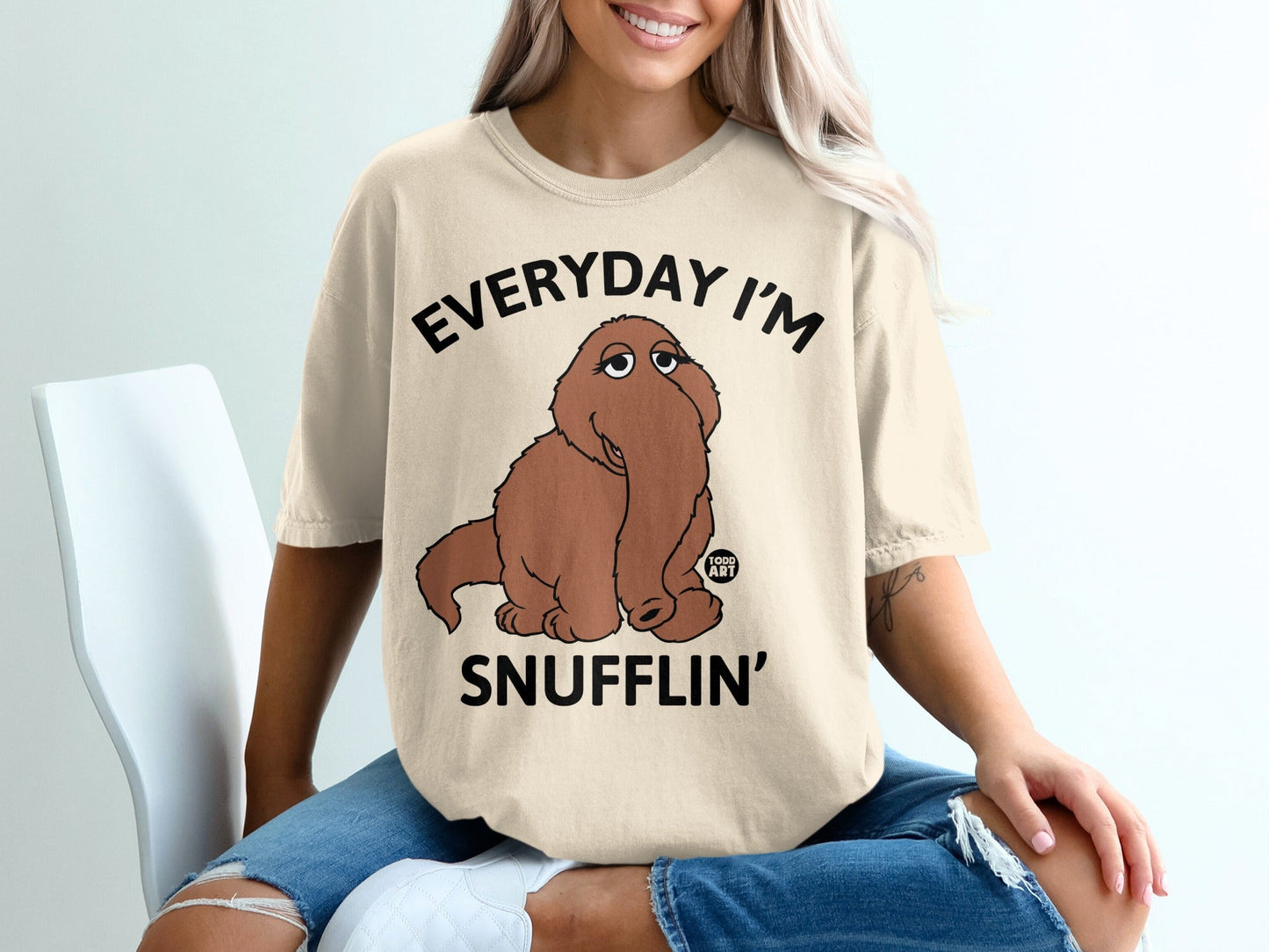 Beige t-shirt with "EVERYDAY I'M SNUFFLIN'" and a cartoon Snuffleupagus.