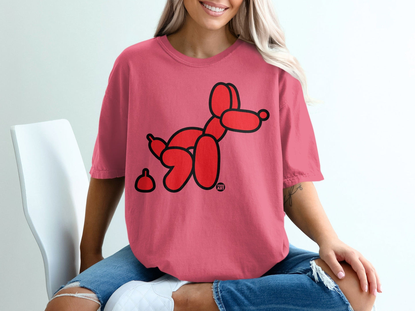 Red balloon dog with a small pile on a pink t-shirt.
