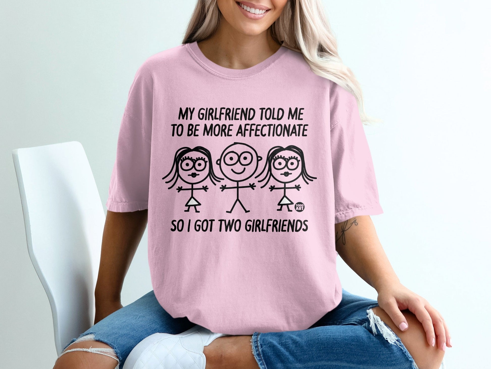Pink t-shirt with graphic of three stick figures and text about girlfriends.