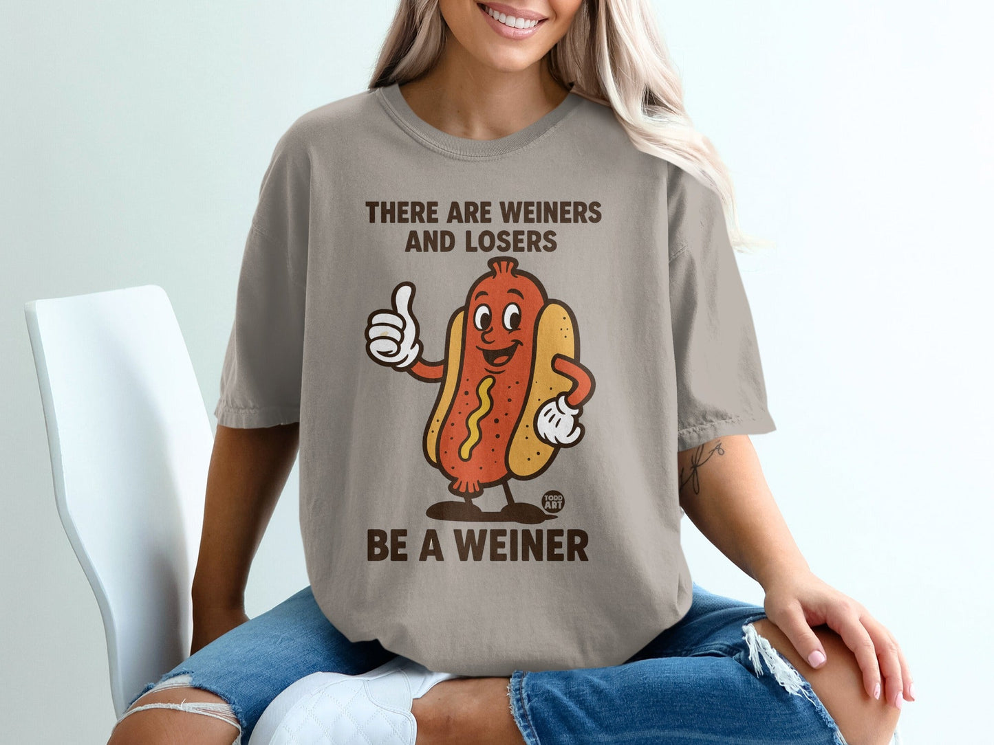 T-shirt with cartoon hot dog giving thumbs up and text "BE A WEINER".