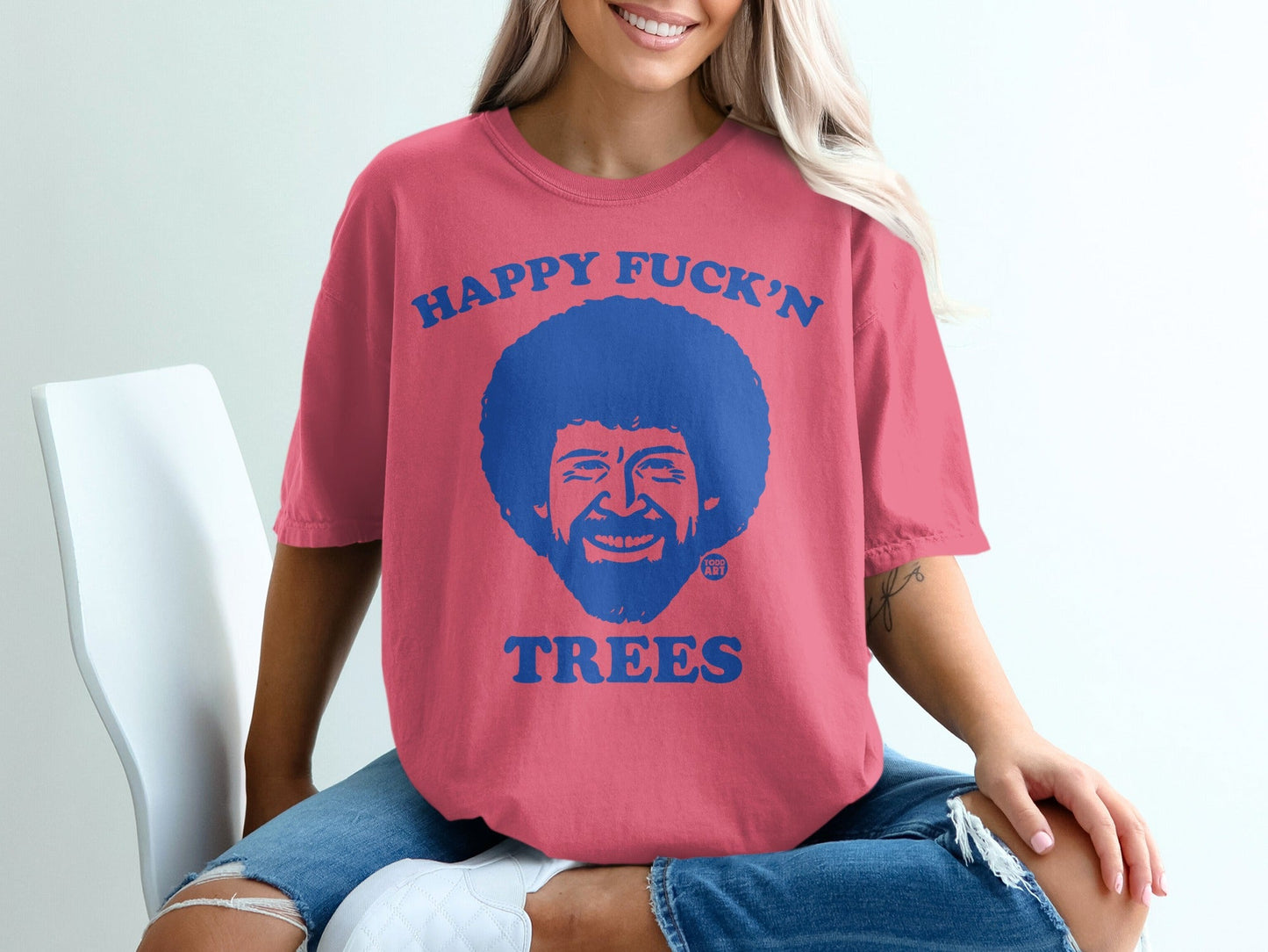 Pink t-shirt with Bob Ross portrait and "Happy Fuck'n Trees" text.