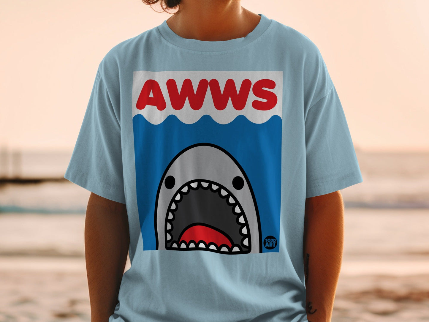 Light blue t-shirt with a cartoon shark graphic and "AWWS" text.
