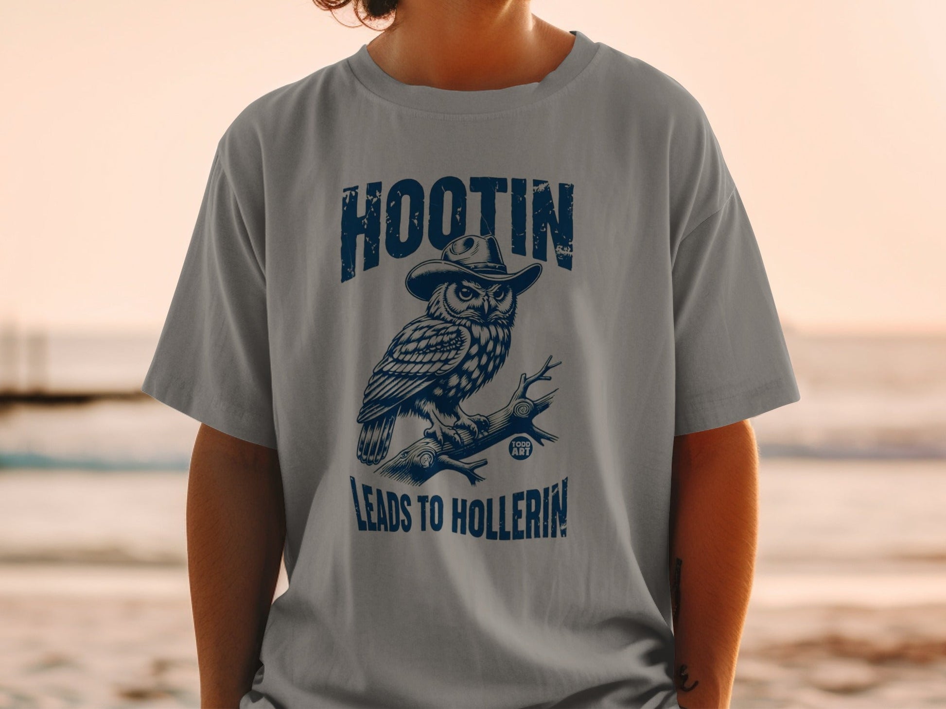 T-shirt with graphic of owl wearing a cowboy hat, text "Hootin' Leads to Hollrin'".