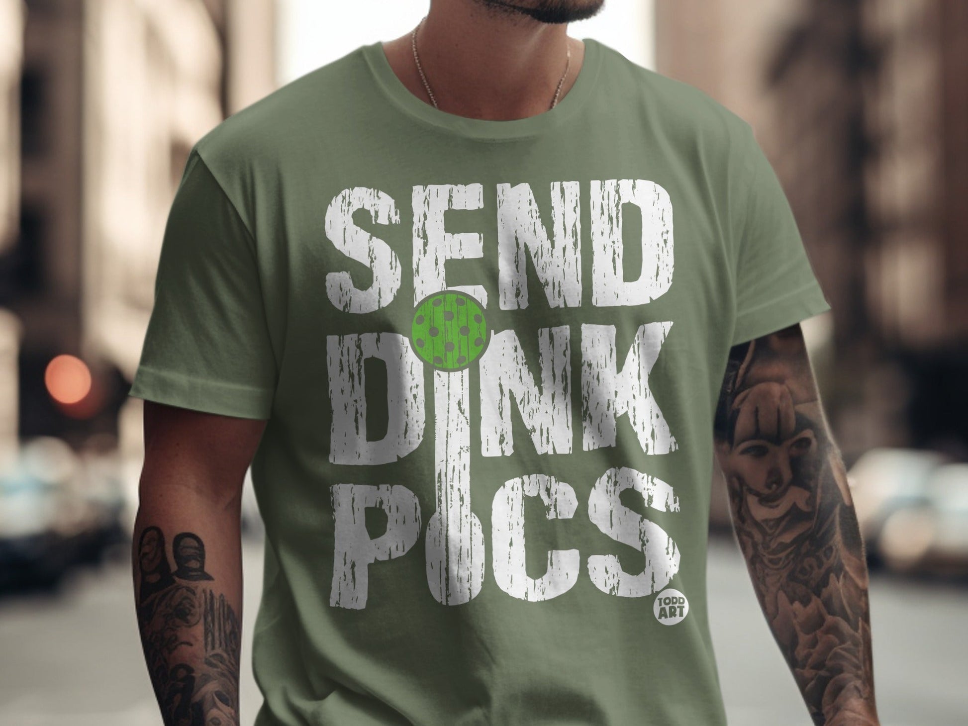 Green t-shirt with white text "SEND DINK PICS" and a pickleball graphic.