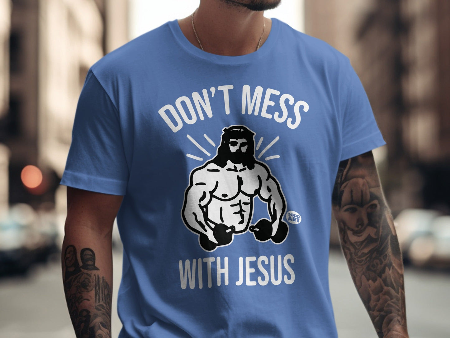 Blue t-shirt with "Don't Mess With Jesus" text and muscular Jesus illustration.