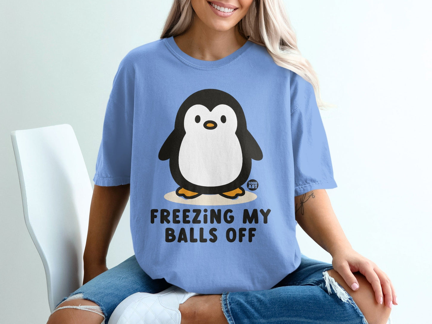 Blue t-shirt with penguin graphic and text "FREEZING MY BALLS OFF".