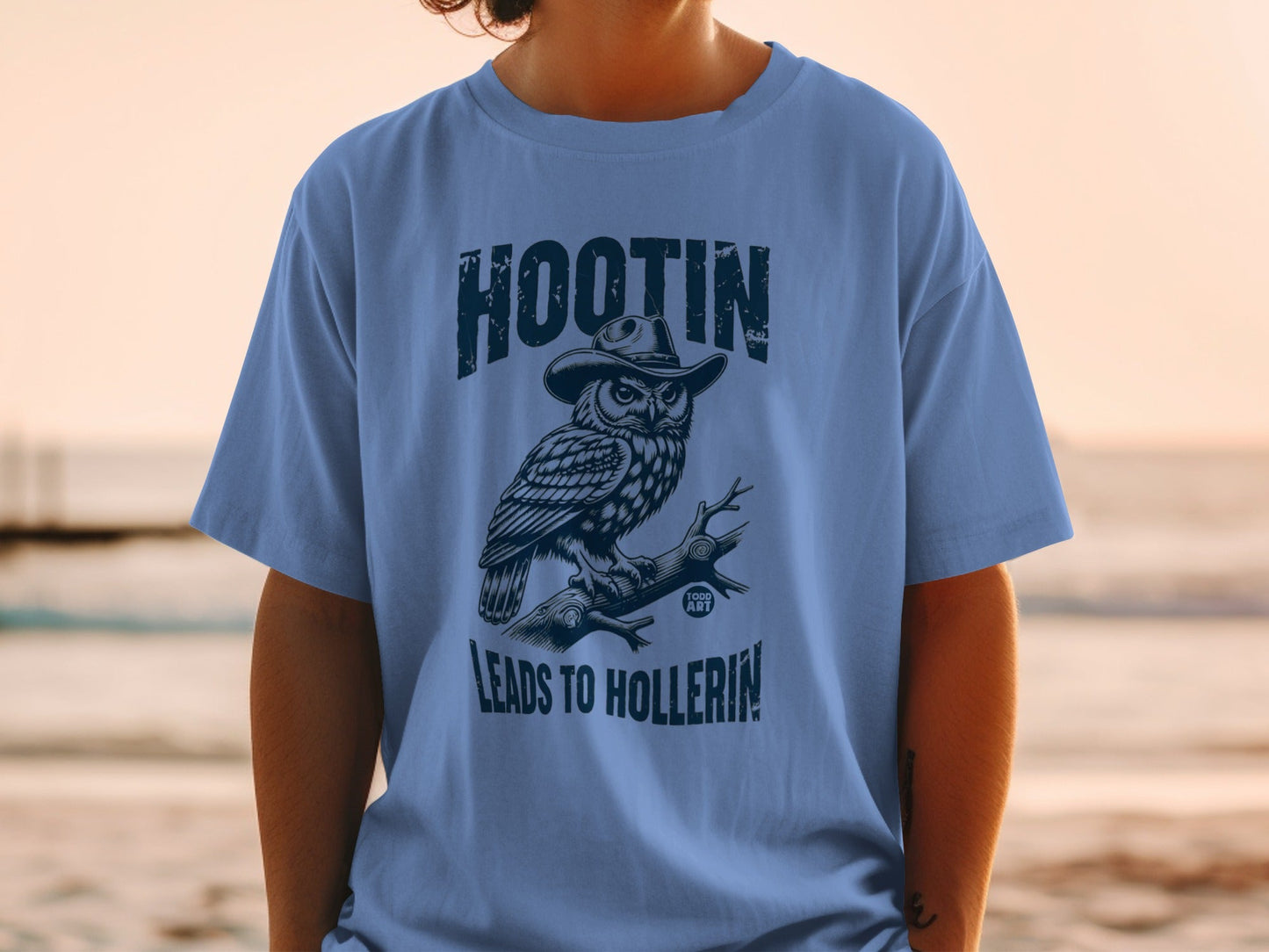 Blue t-shirt featuring an owl wearing a cowboy hat, perched on a branch.