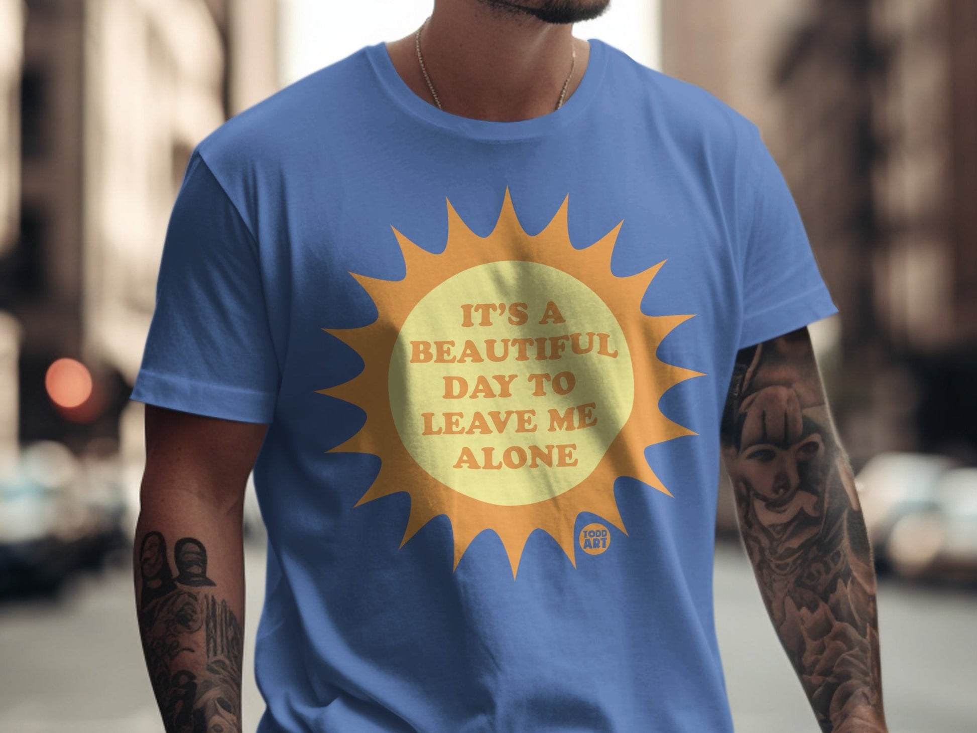 Blue t-shirt with a yellow sun graphic and text "IT'S A BEAUTIFUL DAY TO LEAVE ME ALONE".
