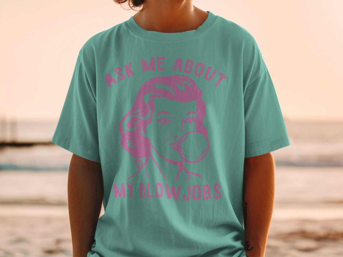 Teal t-shirt with pink retro graphic and text "ASK ME ABOUT MY BLOW JOBS".