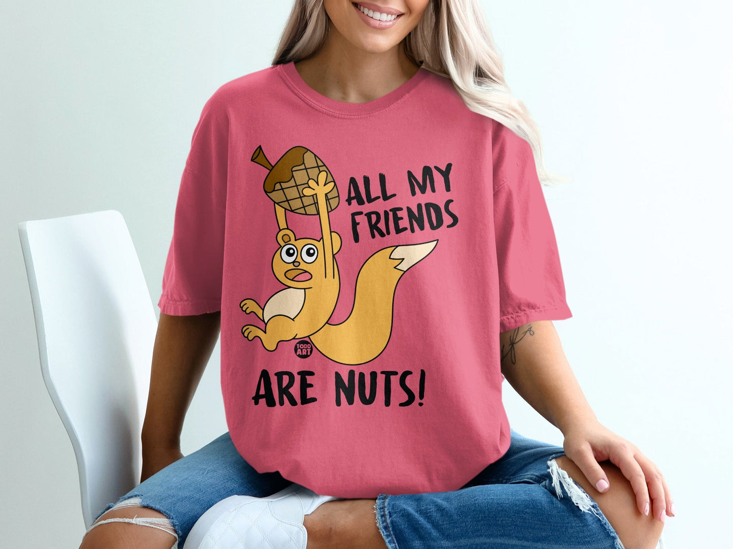 Pink t-shirt with cartoon squirrel holding acorn, text reads "ALL MY FRIENDS ARE NUTS!".
