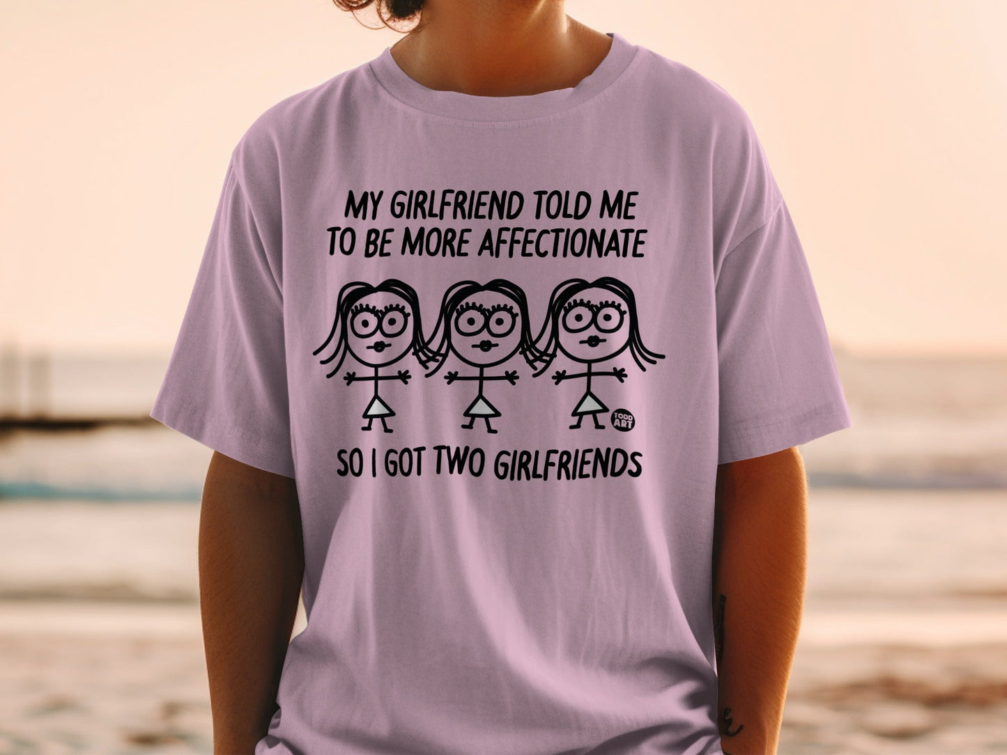 T-shirt with "My Girlfriend Told Me To Be More Affectionate So I Got Two Girlfriends" text and stick figures.