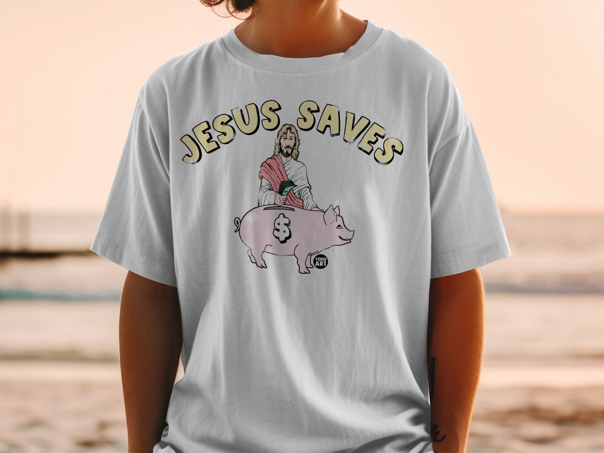 T-shirt with "Jesus Saves" text and Jesus holding a piggy bank.