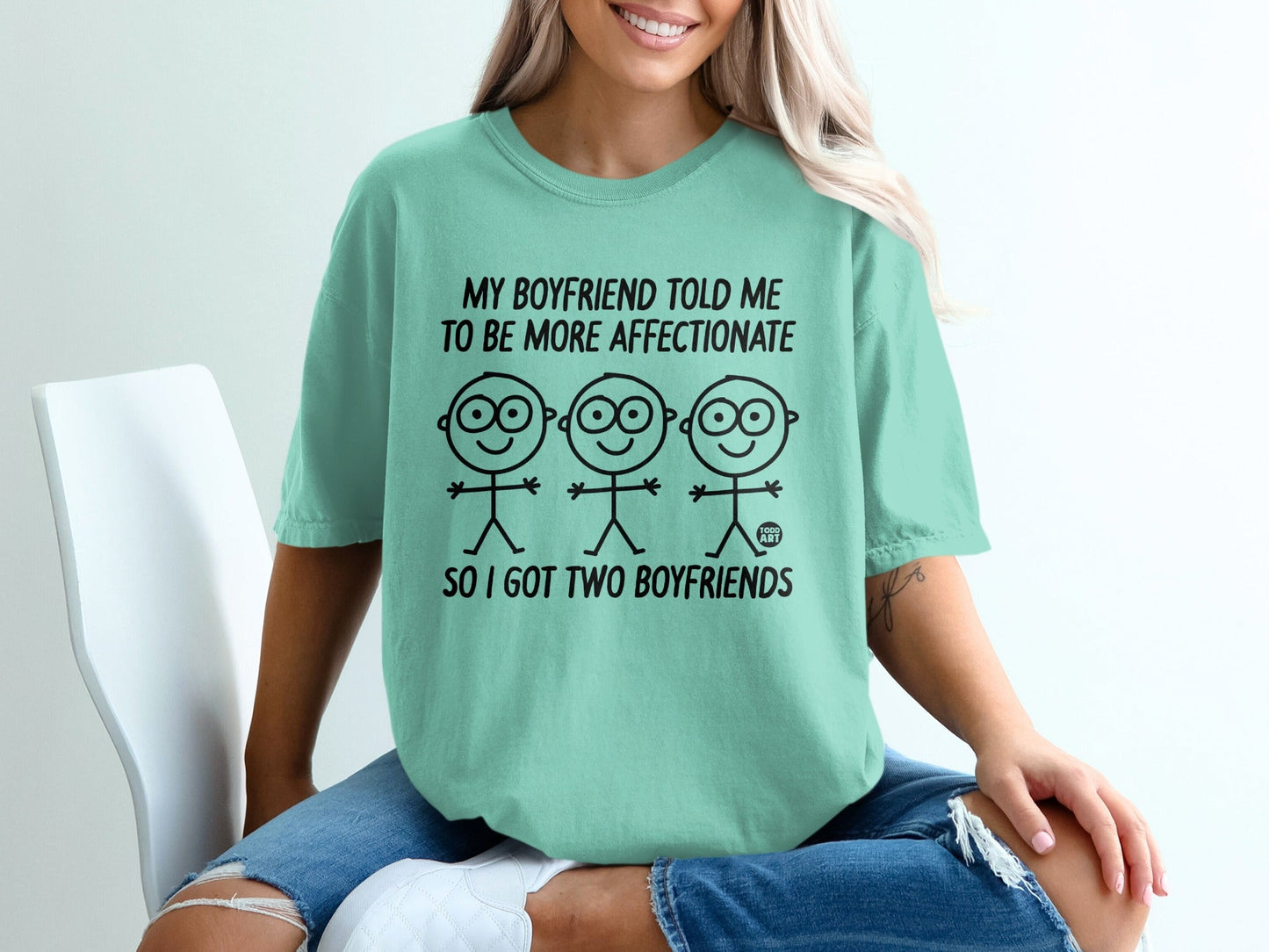Mint t-shirt with cartoon figures and text: "My boyfriend told me to be more affectionate so I got two boyfriends."