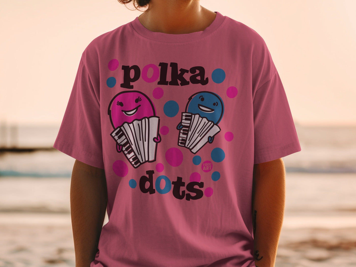 Pink t-shirt with cartoon accordions and "Polka Dots" text.