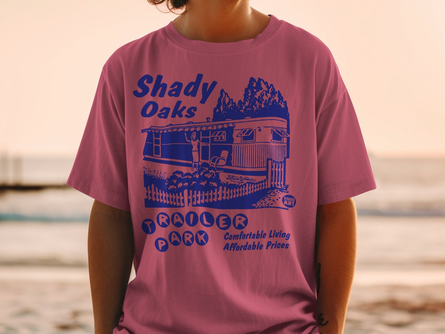 Pink t-shirt with blue graphic: Shady Oaks Trailer Park, comfortable living, affordable prices.
